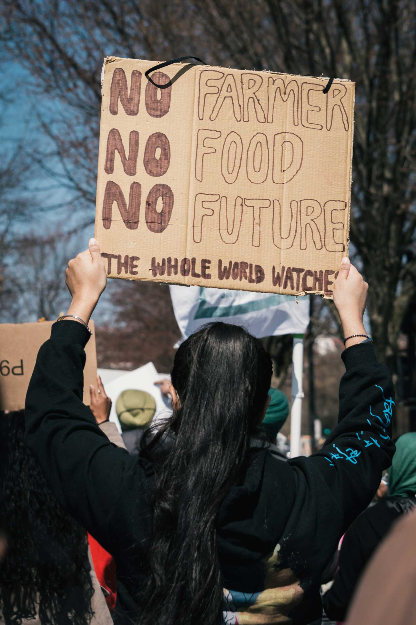 Woman holding a placard with the words ‘no farmer, no food, no future, the whole world watches’.