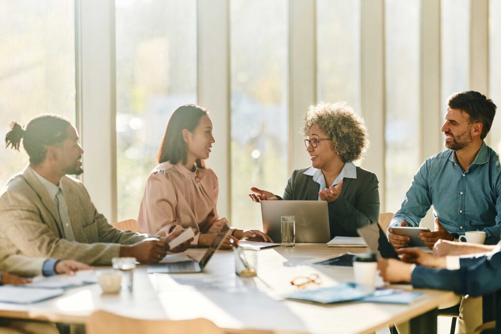 People chatting at a work desk.