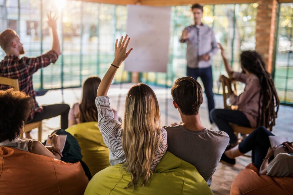 People raising hands at a workshop.