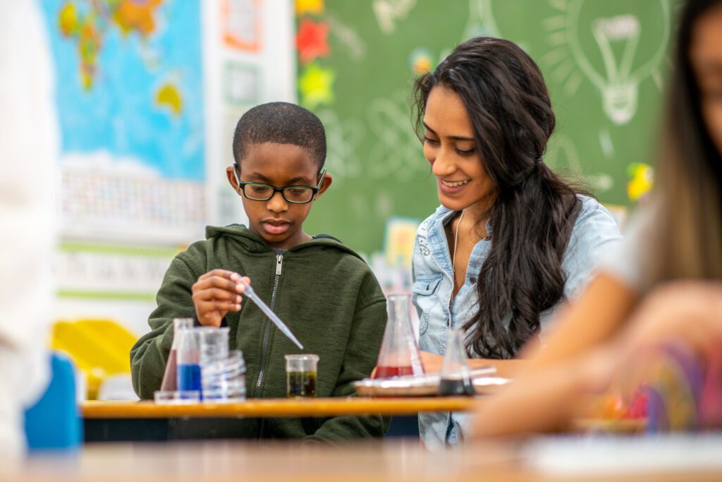 A woman and a boy holding a pipette.