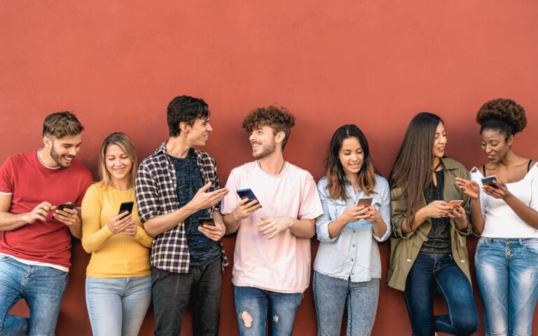 Young smiling people holding their smartphones.