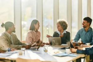 People chatting at a work desk.